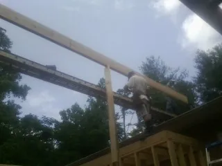 Carpenter setting a ridge beam over a new addition frame — Ice Dam Removal by Roofing Brothers in Sauquoit