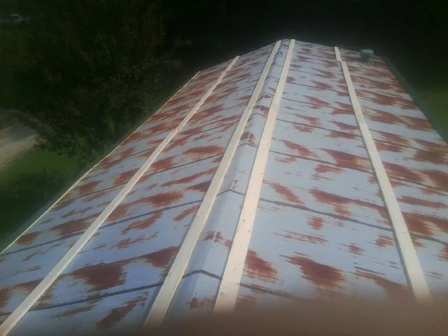 Rusted metal roof panels with new wood purlins before replacement — Storm Damage Roof Repair in Sauquoit by Roofing Brothers