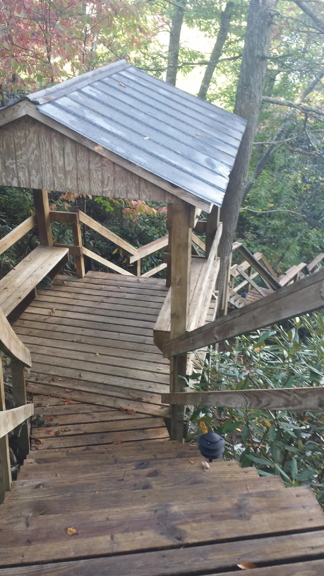Metal roofed shelter over wooden steps on a wooded walkway — Skylight Repair & Installation work by our crew in Sauquoit