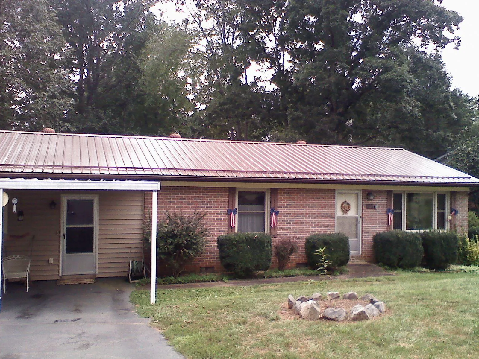 Bronze metal roof and carport on a brick ranch home — Roof Repair work by our crew in Sauquoit